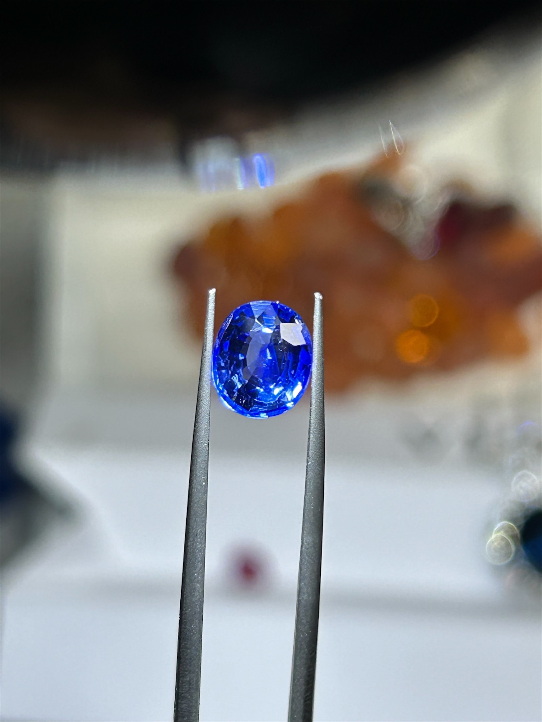 Blue sapphire gemstone held in tweezers